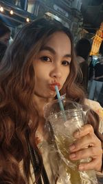 Portrait of young woman drinking glass