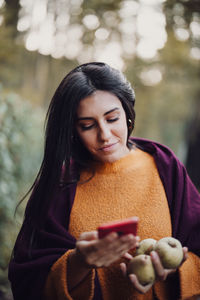 Close-up of young woman using smart phone in forest