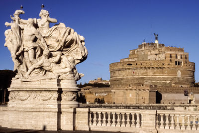 Imposing marble sculpture on bridge over tiber river and saint angelo castle in rome, italy.