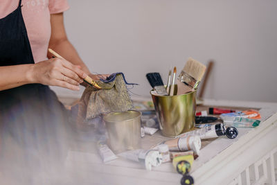 Midsection of woman painting on table