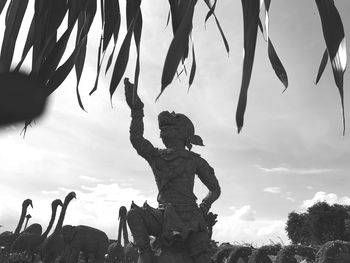 Low angle view of silhouette statue against sky