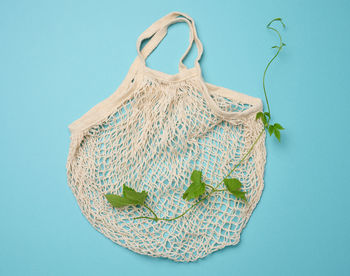 Empty cotton reusable bag on blue background. refusal of plastic, recyclable waste