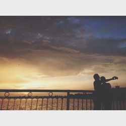 Silhouette of woman against cloudy sky