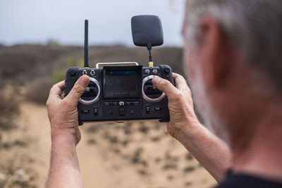 Senior man using telecontrol for drone