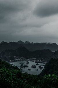 Scenic view of river by mountains against sky