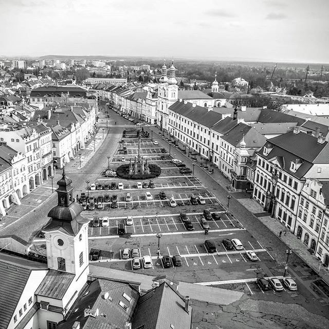 building exterior, architecture, built structure, high angle view, city, cityscape, transportation, car, road, street, residential district, crowded, city life, residential structure, land vehicle, residential building, elevated view, mode of transport, sky, incidental people