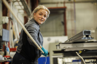 Young female industrial worker working in factory