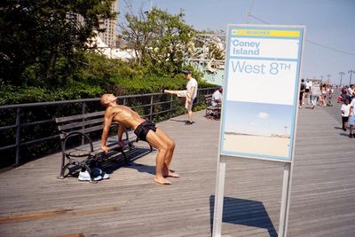 Full length of shirtless man with horse against sky