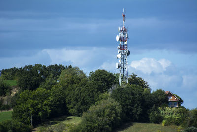 Communications tower and trees against sky