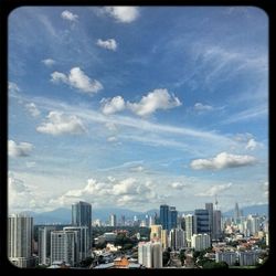 View of cityscape against cloudy sky