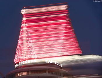 Low angle view of illuminated text against clear sky at night