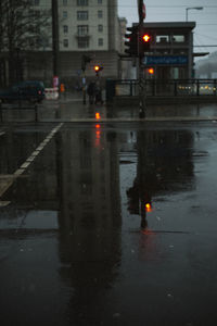 Reflection of illuminated buildings in puddle