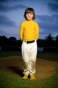 Portrait of a young boy in deshevled yellow and white baseball uniform