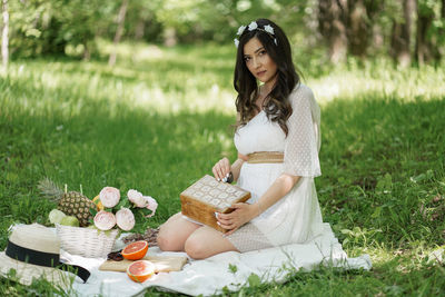 Young woman sitting in basket on field