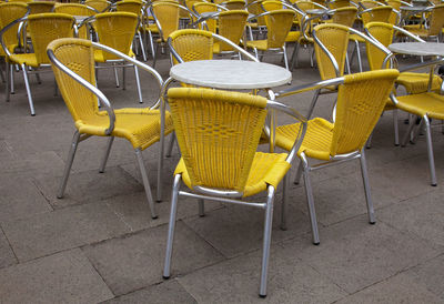 Empty chairs and tables at sidewalk cafe