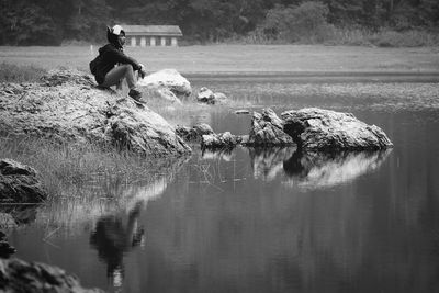 Side view of thoughtful man sitting by lake