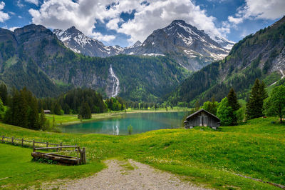 Scenic view of lake by mountains against sky
