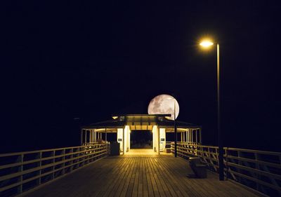 Empty bridge against clear sky at night