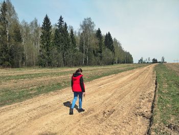 Full length of man walking on field against sky