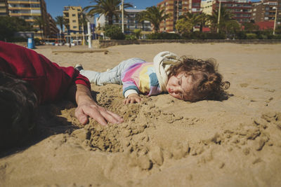 High angle view of woman sitting on sand at beach