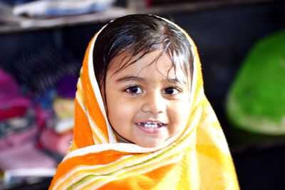 Portrait of cute smiling girl wearing towel at home