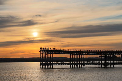 Silhouette pier on sea against sky during sunset