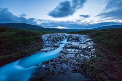 Scenic view of waterfall against sky