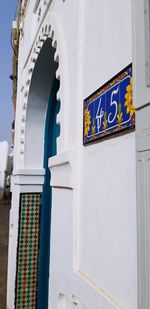 Low angle view of text on white wall of building