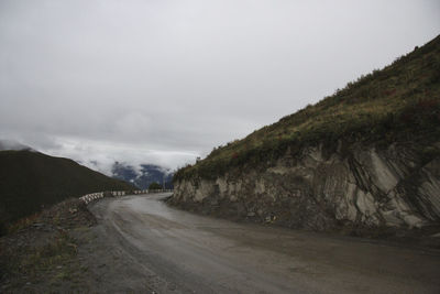 Road by mountain against sky