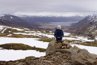 Rear view of woman standing on cliff