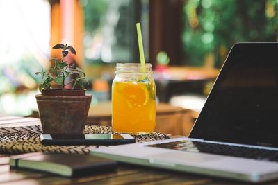 Drink by laptop in mason jar on table