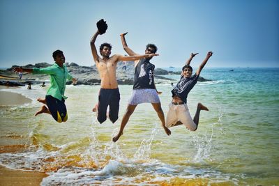 Full length of young woman jumping on beach