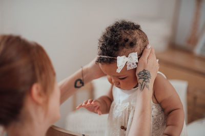 Rear view of mother and daughter at home