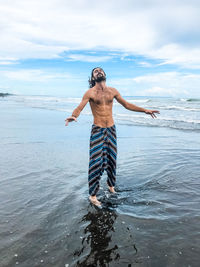 Man standing on beach against sky