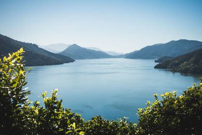 Scenic view of lake and mountains against clear sky