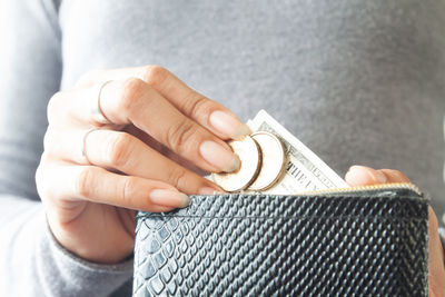 Close-up of woman hand inserting money in wallet