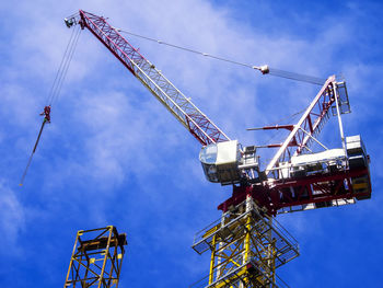 Low angle view of cranes against sky
