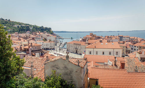 High angle view of townscape by sea against sky