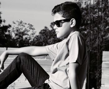 Close-up of boy wearing sunglasses against sky