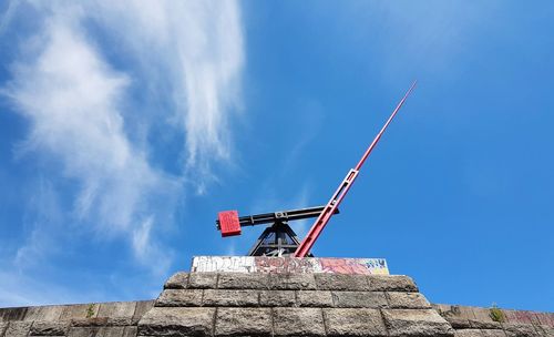 Low angle view of crane against blue sky