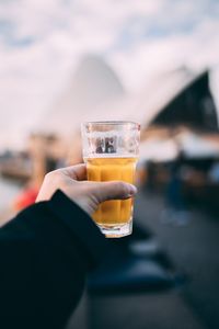 Close-up of hand holding beer glass