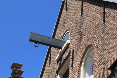 Low angle view of old building against clear blue sky