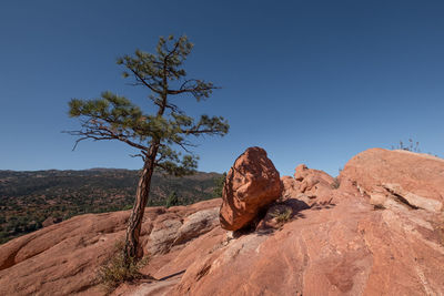 Rock formations on landscape against clear blue sky