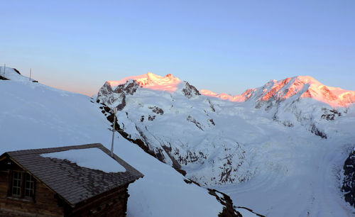 Scenic view of snowcapped mountains against clear sky during winter