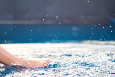 Low section of woman feet in water