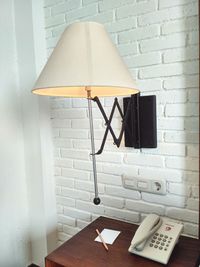 View of electric lamp on table against wall