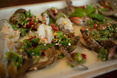 Close-up of thai spicy blue crabs salad sea food served on table.