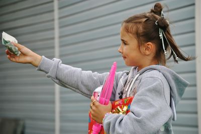 Side view of girl in hooded shirt paying for bubble wand