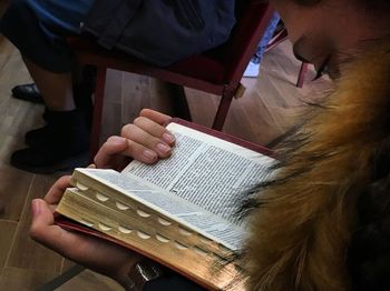 Midsection of person reading book at temple