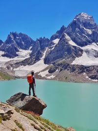 Rear view of man walking on snowcapped mountain